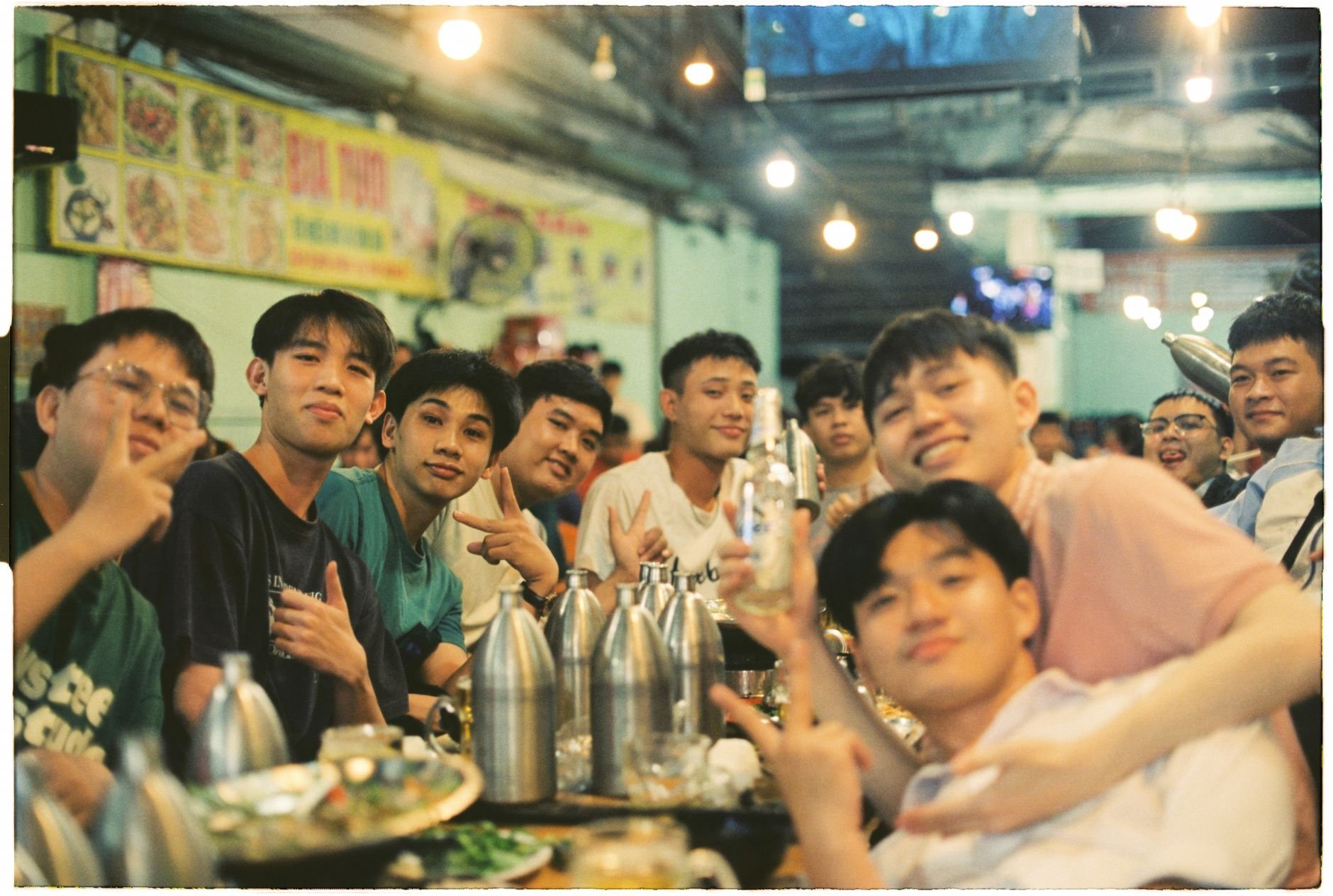A lively group of young adults enjoying a social dinner at a bustling urban eatery.