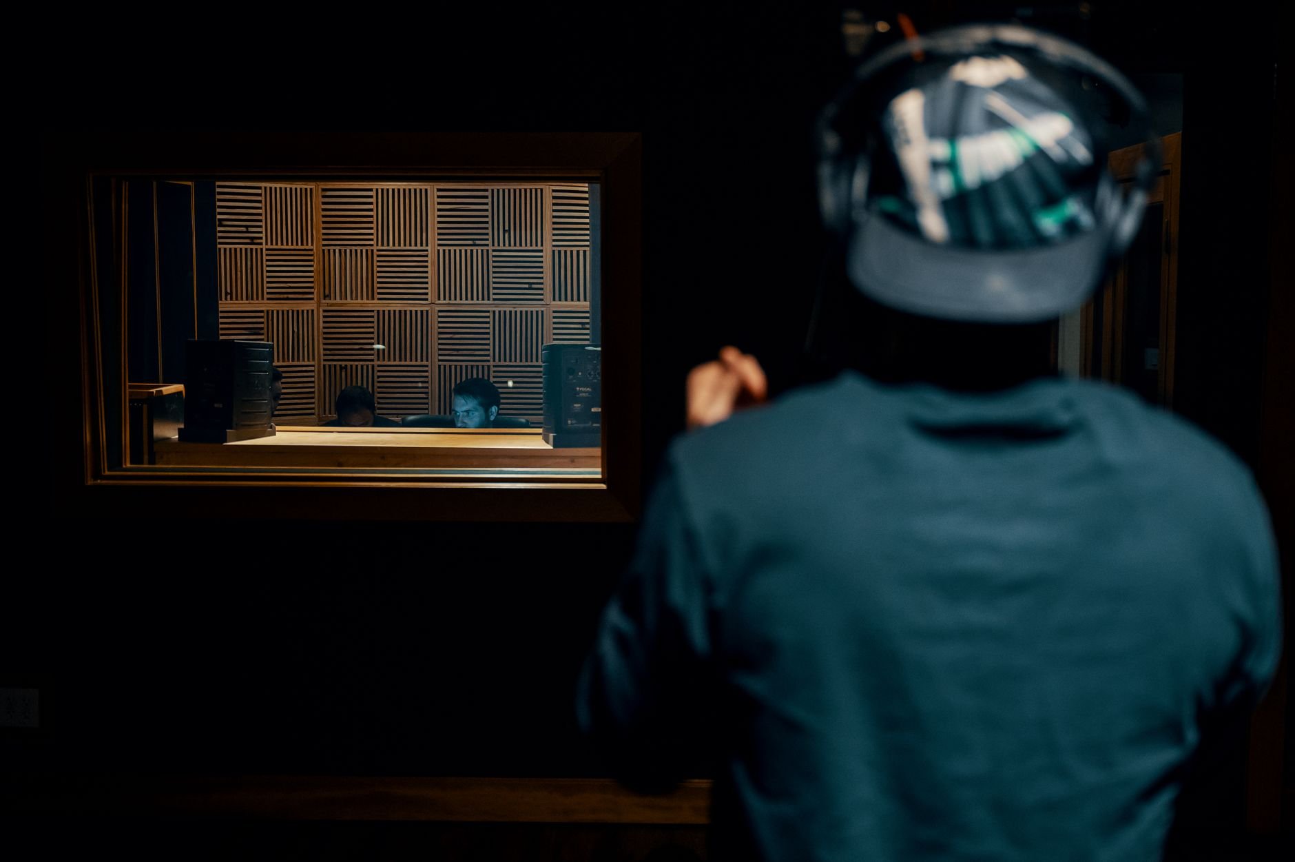 A person in headphones recording music in a professional soundproof studio.